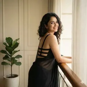 Woman in Backless Saree Leaning on Wooden Railing