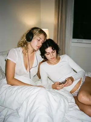 Intimate Candid Lifestyle Photo of Two Women on White Sheets