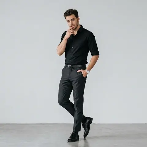 Full-body portrait of a stylish young man standing against